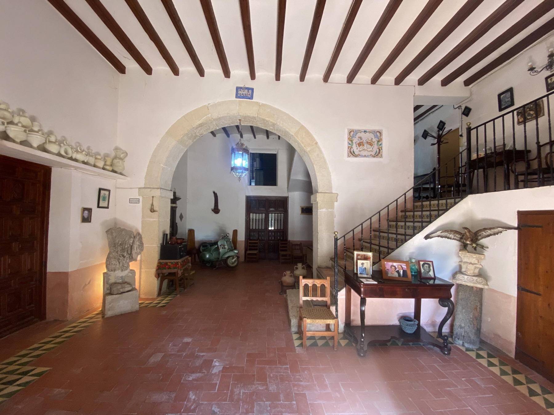 El vestíbulo desde dentro: el arco de medio punto, el farol y la escalera