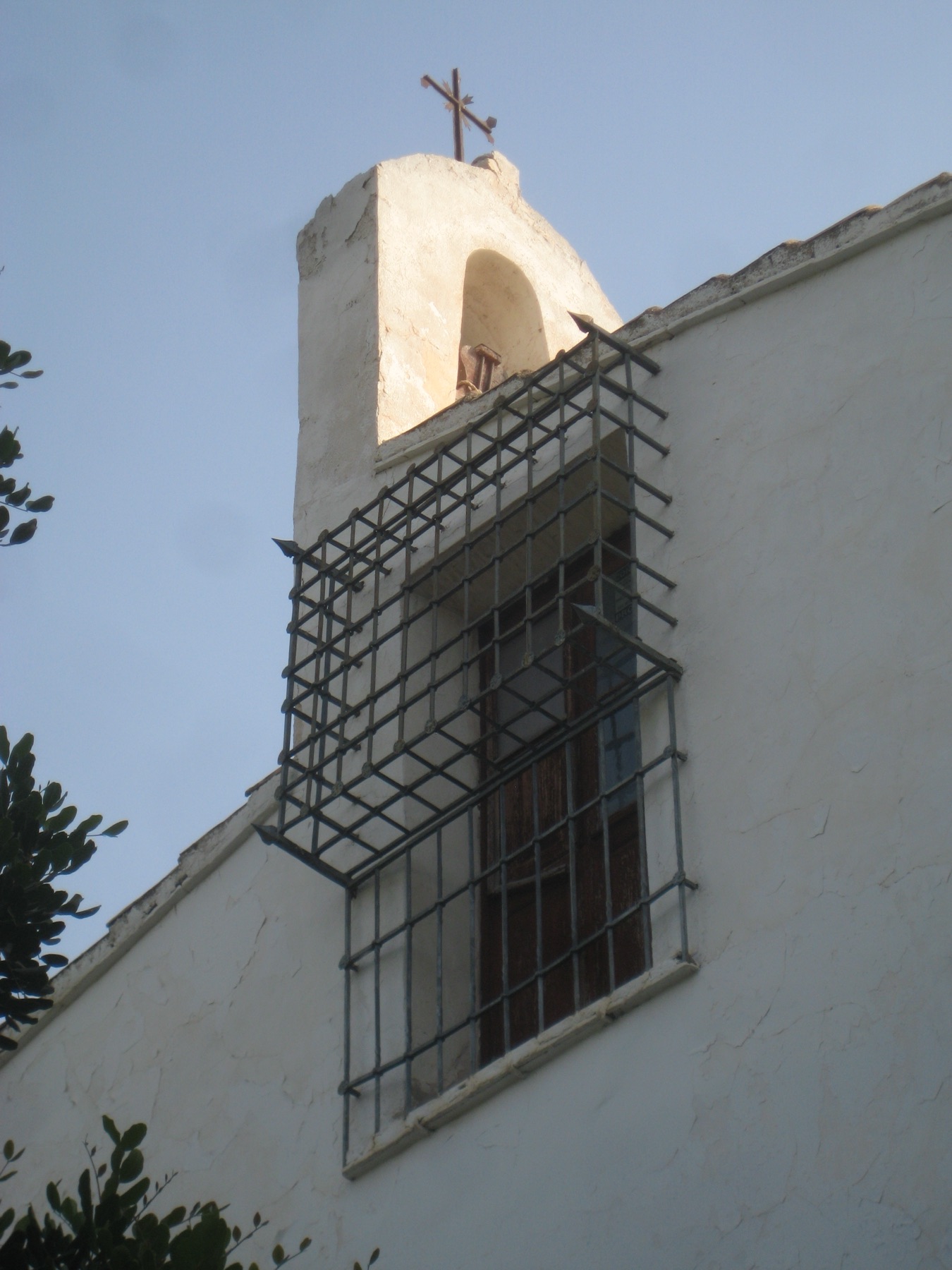 La espadaña de la capilla, con su campana y su cruz